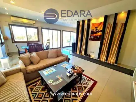 Contemporary living room featuring a beige sofa, coffee table, and decorative elements on the wall.
