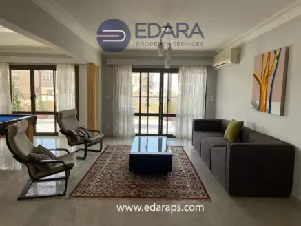 Modern living room featuring a sofa, armchairs, and a coffee table in a well-lit space.