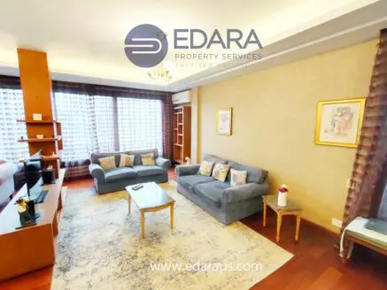 Interior view of a living room featuring a blue couch, coffee table, and decorative elements.