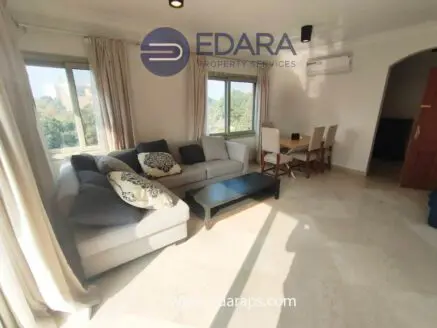 Modern living room featuring a sectional sofa, coffee table, and dining area with chairs.