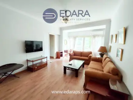 Living room featuring a sofa, coffee table, and television in a bright indoor space.