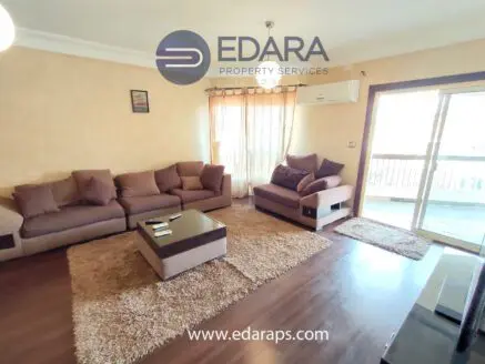 Cozy living room featuring a brown sofa set and a glass coffee table on a plush rug.