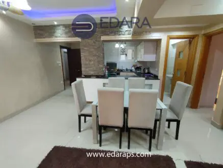 Dining area featuring a rectangular table with six upholstered chairs in a modern interior design.