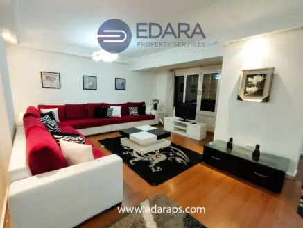 Contemporary living room featuring a red sectional sofa, coffee table, and decorative elements.