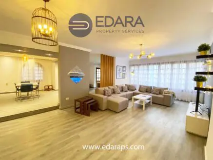 Spacious living room featuring a large sectional sofa, coffee table, and decorative lighting fixtures.