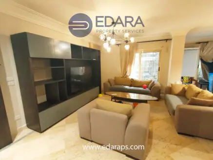 Living room featuring a modern sofa set and a large entertainment unit against the wall.
