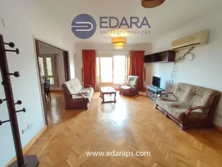 Living room featuring two upholstered sofas, a coffee table, and a television in a bright indoor space.