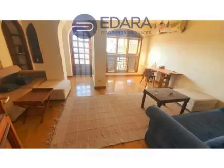 Interior view of a living room featuring seating areas and a small table.