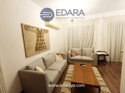 Modern living room featuring a gray sofa set and a wooden coffee table on a patterned rug.