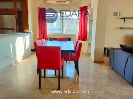 Dining area featuring a rectangular table with red chairs and a modern interior design.