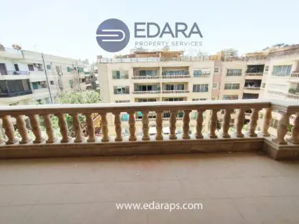 Balcony with a railing overlooking buildings in Cairo, featuring a clear view of the surrounding architecture.