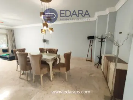 Dining room featuring a glass table and upholstered chairs in a modern interior design.