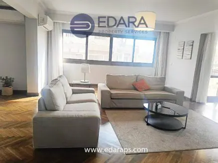 Modern living room featuring a light-colored sofa set and a round coffee table with decorative items.
