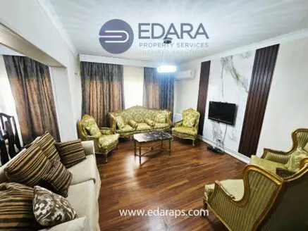 Elegant living room featuring gold-accented furniture and a flat-screen TV on the wall.