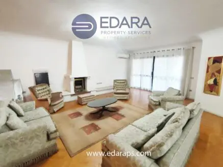 Living room featuring a light-colored sofa set, a round coffee table, and a fireplace with a white mantel.