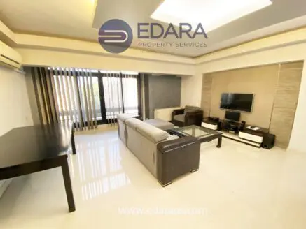 Spacious modern living room with a sofa, coffee table, and television setup.