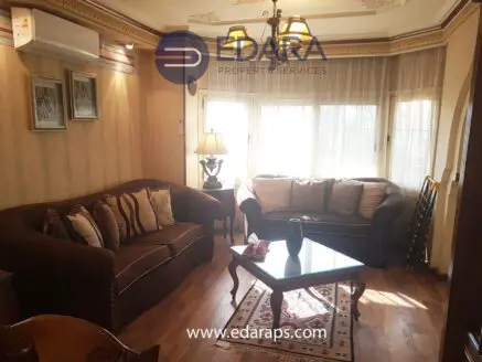Cozy living room featuring a brown sofa set, coffee table, and decorative lamp near a window.