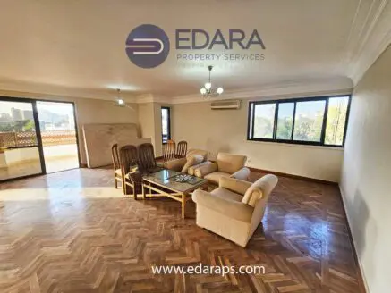 Spacious living room featuring a sofa set, coffee table, and large windows with natural light.