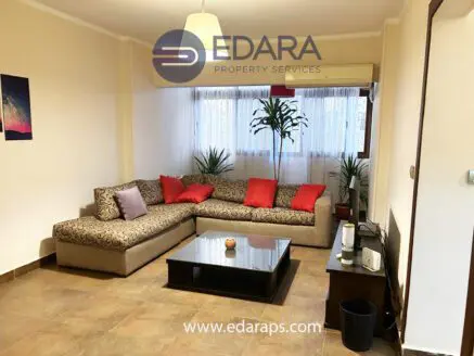 Living room featuring a large sectional sofa with red cushions and a coffee table in front.