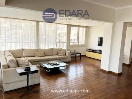 Spacious living room featuring a light-colored sofa, coffee table, and wooden flooring.