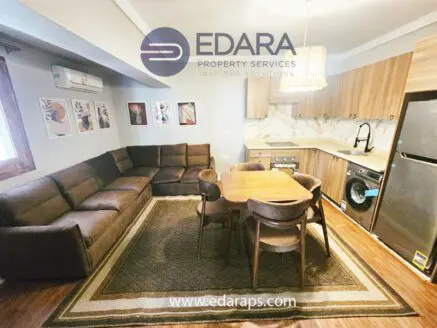 Interior view of a modern living room with a brown sectional sofa and a dining table.