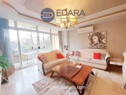 Modern living room featuring a sofa, coffee table, and decorative elements in a well-lit space.
