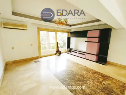 Spacious living room featuring built-in shelving and large windows for natural light.