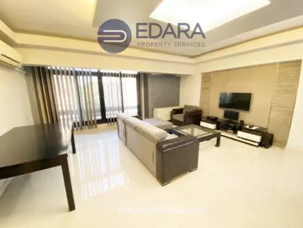 Contemporary living room with a sofa, coffee table, and television setup in a bright space.