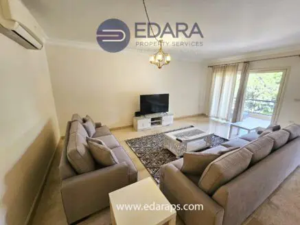 Modern living room featuring two gray sofas and a television on a white media console.