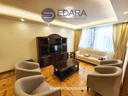 Modern living room featuring a beige sofa, armchairs, and a wooden coffee table.