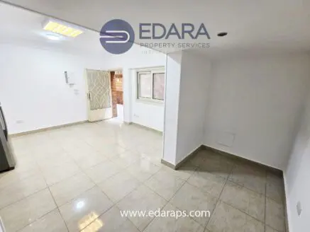 Interior of a residential space with tiled flooring and a doorway leading outside.