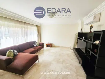 Modern living room featuring a brown sofa, television unit, and decorative elements.