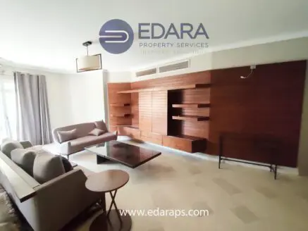 Contemporary living room with wooden wall unit and comfortable seating arrangement.