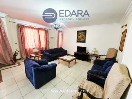 Living room featuring blue sofas, a coffee table, and curtains in a neutral color scheme.