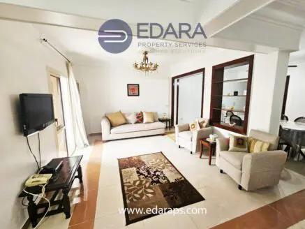 Interior view of a living room featuring a sofa, armchairs, and a decorative rug.