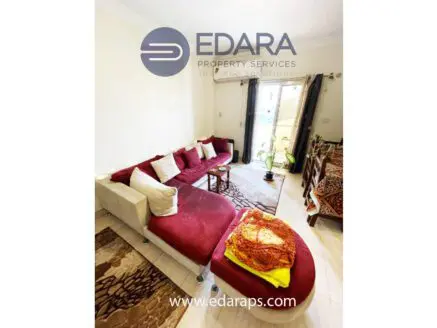 Living room featuring a red sectional sofa with decorative pillows and a colorful throw.