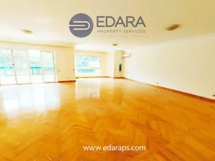 Bright and spacious empty room featuring wooden flooring and large windows for natural light.