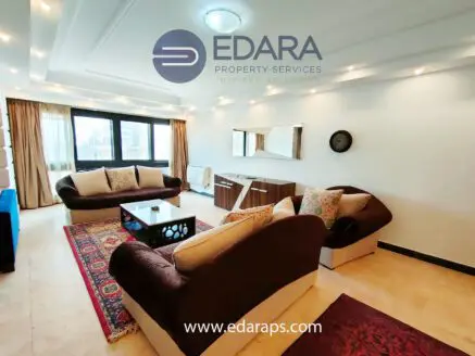 Modern living room featuring two sofas, a coffee table, and a wall-mounted clock.