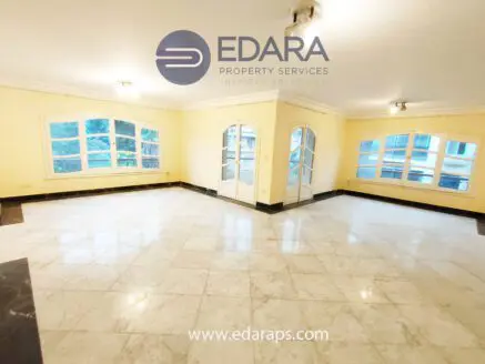 Bright living room featuring marble flooring and large windows for natural light.