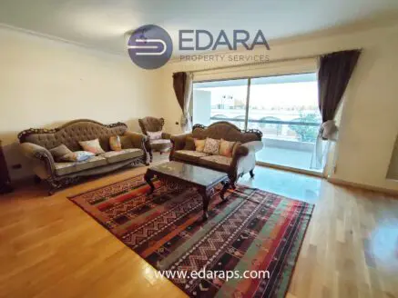 Living room featuring two upholstered sofas and a coffee table on a patterned rug.