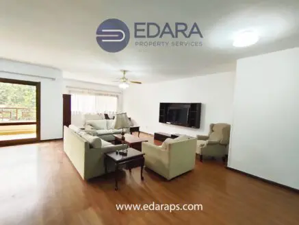 Bright living room featuring a sofa set, coffee table, and television mounted on the wall.