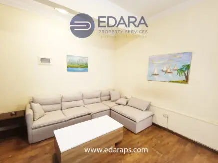 Contemporary living room featuring a light-colored sectional sofa and a white coffee table.