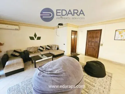 Interior view of a living room featuring a seating area with couches and bean bags.