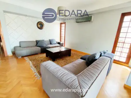 Living room featuring gray sofas arranged around a central coffee table on a patterned rug.