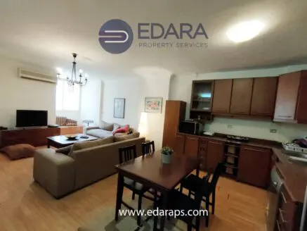 Interior view of a modern apartment featuring a living room, dining area, and kitchen.