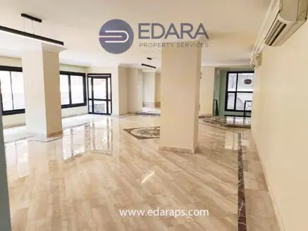 Interior view of a spacious property featuring marble flooring and large windows for natural light.