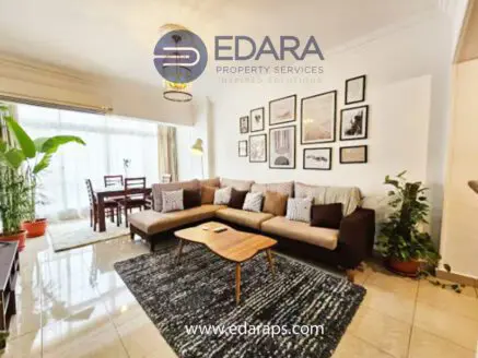 Living room featuring a brown sectional sofa, decorative pillows, and framed wall art.