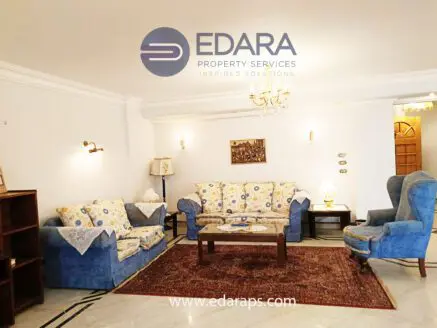Living room featuring a blue sofa set, coffee table, and decorative elements in a neutral color scheme.