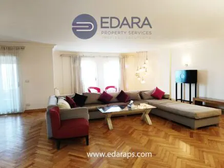 Spacious living room featuring a sectional sofa with red and gray cushions and a wooden coffee table.