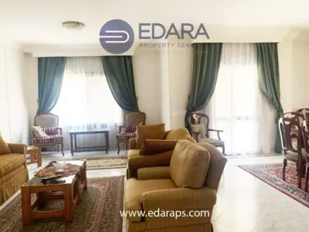 Cozy living room featuring a sofa, armchairs, and decorative curtains in neutral tones.